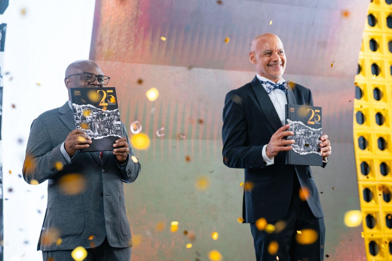 CEOrt leaders holding the 25-year anniversary publication